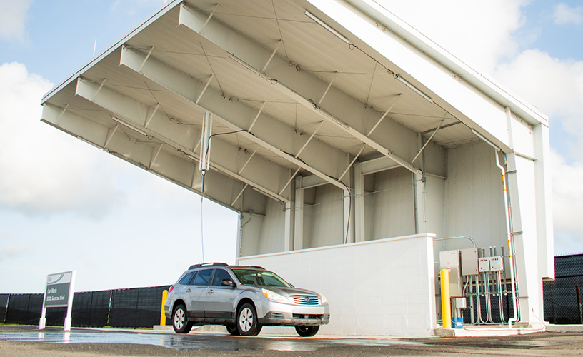 A gray car parked at the on-site car wash structure.